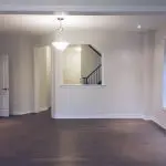 Spacious open-concept living area with smooth off-white walls, dark hardwood floors, and crisp white baseboards, expertly finished by local Painters in Kirkland, WA.