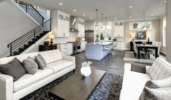 Bright, modern open-concept living space featuring a freshly painted interior with white cabinetry, neutral walls, and clean finishes throughout the kitchen and living areas.